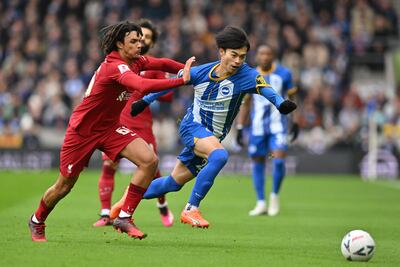 El japonés Kaoru Mitoma, mediocampista del Brighton, se escapa de la marca de Trent Alexander-Arnold, lateral inglés del Liverpool, durante el partido disputado ayer.