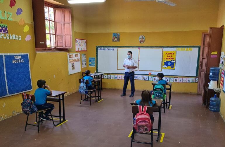 Un docente y cuaro alumnos en un aula de una escuela de Villarrica. en esta institución solo asistieron ochos estudiantes para las clases presenciales.