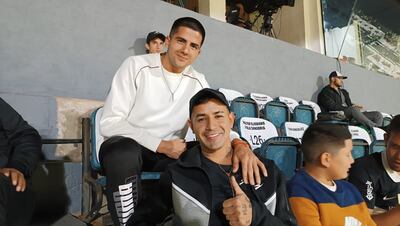 Derlis González (d), futbolista de Olimpia, en compañía de Mateo Gamarra en la zona de Preferencia de estadio Manuel Ferreira durante el partido contra General Caballero de Juan León Mallorquín por la décimo octava jornada del torneo Apertura 2023 del fútbol paraguayo.