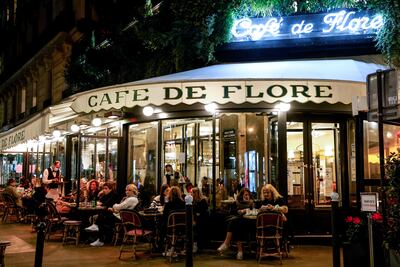 Clientes de la famosa brasserie Cafe de Flore, en París comparten tragos el 26 de octubre, antes de la entrada en vigencia del toque de queda que busca frenar la propagación del coronavirus.