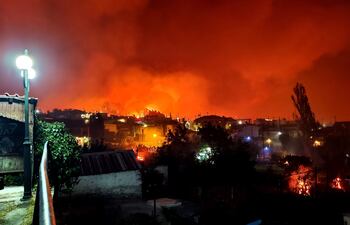 El humo y las llamas se elevan cuando un incendio forestal quema el área de Skepasti en la isla de Evia, costa este de Grecia central, 05 de agosto de 2021.