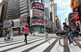Varias personas cruzan una calle cerca de Times Square, en Nueva York.