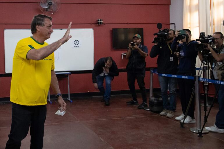 El presidente brasileño Jair Bolsonaro saluda tras votar hoy, en un puesto de votación en Río de Janeiro (Brasil). (EFE)