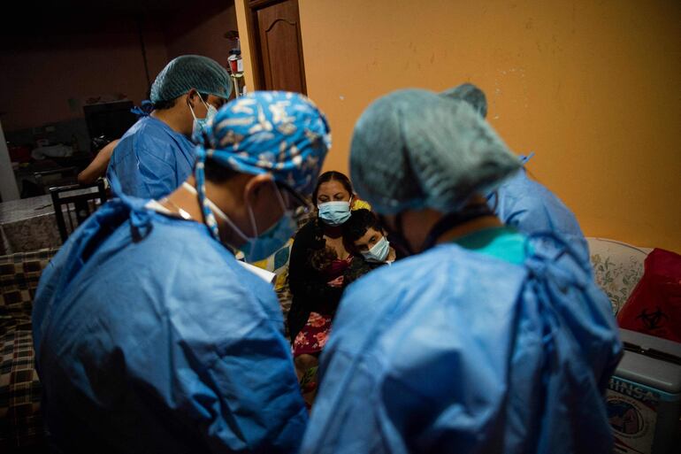 Profesionales de la salud visitan una vivienda en las afueras de Lima, la capital peruana. 