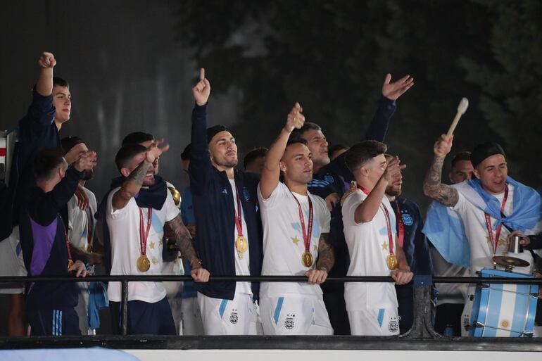 Los jugadores de la selección de Argentina a bordo del bus descapotable durante el recorrido hasta el predio de Ezeiza en compañía de miles y miles de argentinos, que recibieron al plantel en el Aeropuerto Internacional de Ezeiza después de la conquista del Mundial Qatar 2022. 