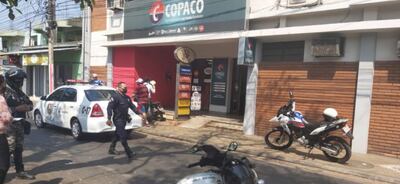Agentes policiales custodian la entrada a la oficina de Copaco en San Lorenzo, donde ocurrió el fatal intento de asalto.