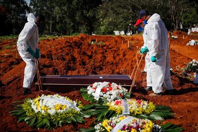 Unos trabajadores colocan un ataúd dentro de una tumba en el cementerio Vila Formosa, el 24 de marzo de 2021, en Sao Paulo (Brasil).