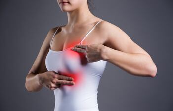 Una mujer se palpa los senos.