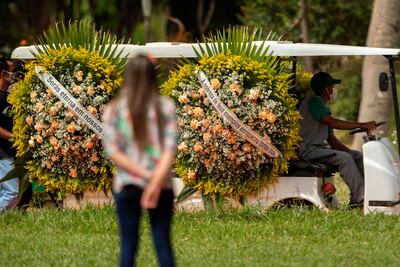 Un trabajador transporta adornos florales en el cementerio Campo de Esperanza, en Brasilia (Brasil).