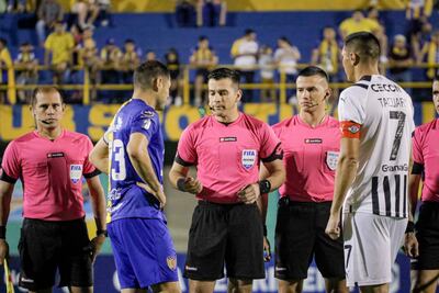 El árbitro Derlis López (c) realiza el sorteo en la previa de Sportivo Luqueño y Libertad en el Feliciano Cáceres por la decimocuarta jornada del torneo Apertura 2023 del fútbol paraguayo.