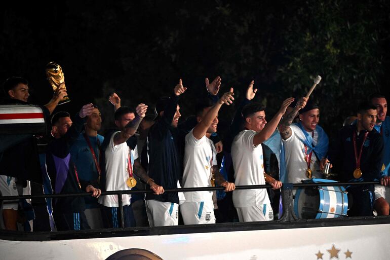 Los jugadores de la selección de Argentina a bordo del bus descapotable durante el recorrido hasta el predio de Ezeiza en compañía de miles y miles de argentinos, que recibieron al plantel en el Aeropuerto Internacional de Ezeiza después de la conquista del Mundial Qatar 2022. 