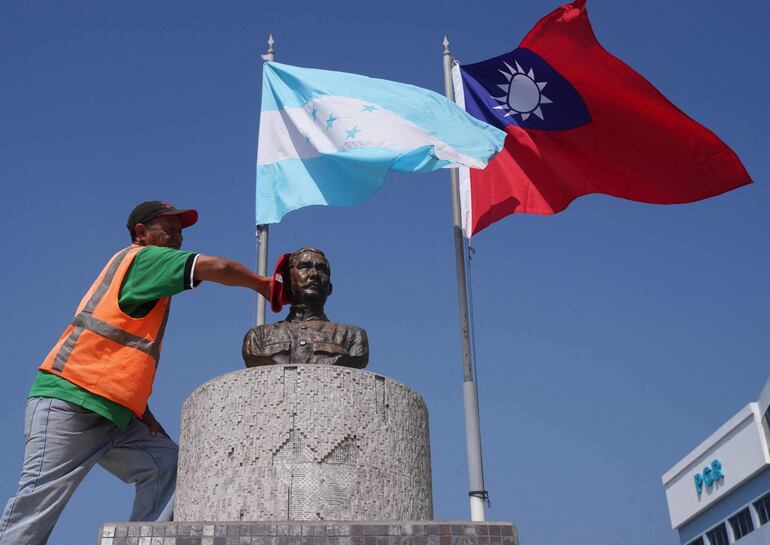 Un funcionario municipal limpia el busto dedicado al expresidente de Dr. Sun Yat-sen, en la plaza de la República de China en Tegucigalpa. (AFP)