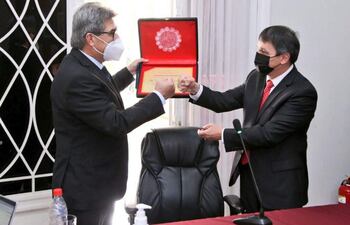 El diputado Roberto Eudez González (izq.) recibe una condecoración por su gestión al frente del CM, de parte de su nuevo presidente, Oscar Paciello.