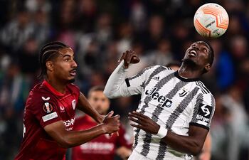 Paul Pogba, de Juventus, intenta controlar el balón ante el acoso de Loic Bade, jugador del Sevilla, durante el partido de ayer.