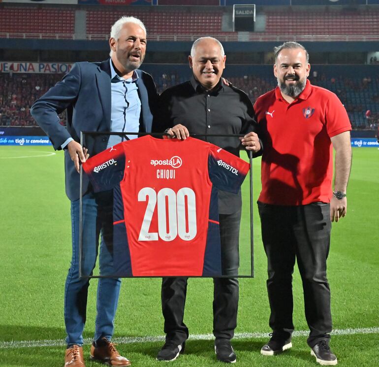 El presidente Juan José Zapag entregó a Francisco Arce una camiseta encuadrada por sus 200 partidos dirigidos al Ciclón. También aparece en la gráfica el directivo Ariel Martínez.