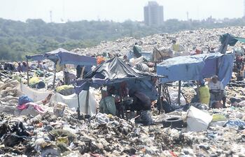 Gancheros de Cateura esperan la llegada de camiones con basura para separar los residuos. El vertedero municipal, desde hace varios años en manos privadas, es objeto investigación.