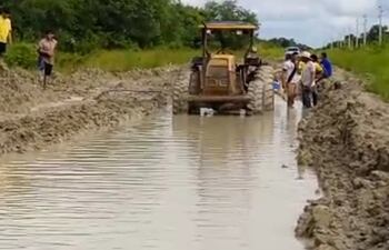 Personal y maquinarias de las estancias Profecía y Techapora desaguando el camino inundado que conduce a los distritos de Fuerte Olimpo y Bahía Negra.