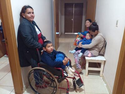 Tres madres de familia y sus hijos esperan su turno en el pasillo del centro de salud de Guayaybi