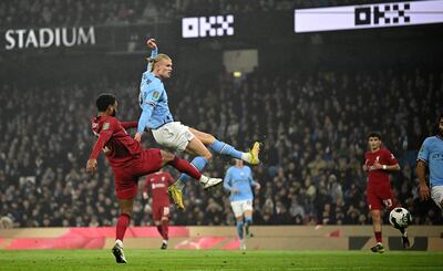 El delantero noruego del Manchester City, Erling Haaland (R), anota el gol de apertura durante el partido de fútbol de la cuarta ronda de la Copa de la Liga inglesa entre el Manchester City y el Liverpool, en el estadio Etihad de Manchester el 22 de diciembre de 2022.