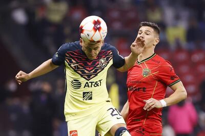 El paraguayo Richard Sánchez, jugador del América, cabecea el balón anticipándose a Maximiliano Silvera, del FC Juárez.