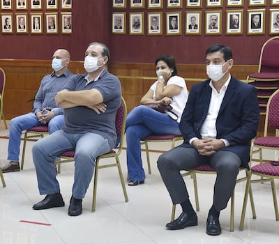 El exministro y actual parlasuariano Enzo Cardozo (der.) espera con otras personas el inicio de la audiencia preliminar.