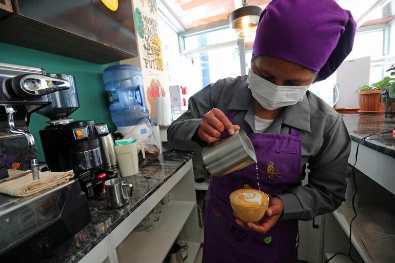 La barista boliviana Ana María Condori mientras prepara un café latte en la tienda-cafetería Origen Eco de las Aves en La Paz (Bolivia).