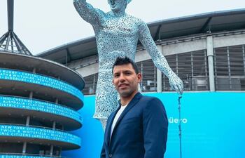 Sergio "Kun" Agüero posa frente a su estatua a un costa del estadio del Manchester City.