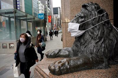 Personas con mascarillas caminan cerca de los grandes almacenes Mitsukoshi en el distrito comercial de Ginza en Tokio, Japón.