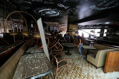 Workers clean debris from a restaurant in Dt Beirut souks on August 6, 2020 in the aftermath of a massive explosion in the Lebanese capital. (Photo by JOSEPH EID / AFP)