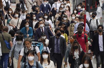 Peatones con tapabocas transitan por el famoso cruce de Shibuya en Tokyo, Japón.
