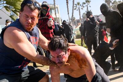 Manifestantes anti-Trump rocían a partidarios del presidente estadounidense durante un enfrentamiento el sábado en San Diego, California.