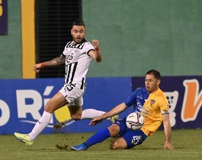 Héctor Villalba de Libertad en la disputa del balón con Pablo Aguilar del Sportivo Luqueño, en el Feliciano Cáceres.