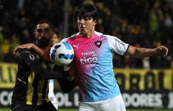 Marcelo Moreno Martins intenta controlar el esférico ante la presión del zaguero uruguayo Hernán Menosse. EFE