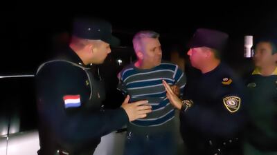 El abogado Edgar Daniel Cáceres Báez (centro) abordado por los uniformados que intentan calmarlo.