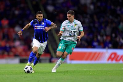 Juan Escobar (i), jugador paraguayo de Cruz Azul, disputa un balón con Santiago Ormeño de León, durante el partido jugado el miércoles y que ganó el equipo felino.