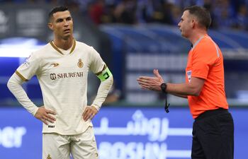 Cristiano Ronaldo, delantero de Al Nassr's, habla con el árbitro inglés Michael Oliver (R) durante el partido que el equipo del astro portugués perdió 2-0 contra Al-Hilal en el clásico de la Súper Liga de Arabia Saudí.