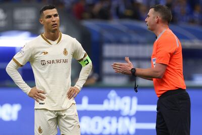 Cristiano Ronaldo, delantero de Al Nassr's, habla con el árbitro inglés Michael Oliver (R) durante el partido que el equipo del astro portugués perdió 2-0 contra Al-Hilal en el clásico de la Súper Liga de Arabia Saudí.