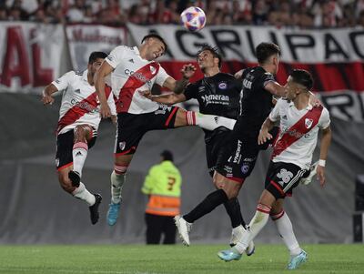 El defensor de River Plate Enzo Díaz (2-L) y el defensor de Argentinos Juniors Kevin Mac Allister (3-L) saltan para un cabezazo durante el partido del torneo de la Liga Argentina de Fútbol Profesional en el estadio El Monumental de Buenos Aires, el 12 de febrero de 2023.