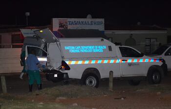 Los miembros de los Servicios de Patología Forense se paran cerca de sus vehículos en la escena de un tiroteo masivo en Gqeberha, Sudáfrica, este 29 de enero de 2023.