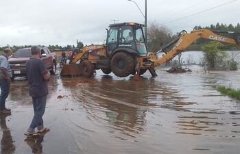 Una maquinaria de la Municipalidad de Santaní trabaja en la apertura de una de las alcantarillas taponadas.