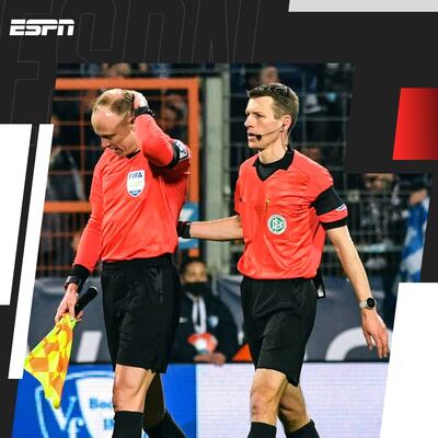 Christian Gittelmann (i), juez línea que fue agredido en la cabeza, abandona el campo junto al árbitro Benjamin Cortus.