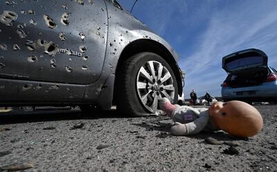 Un automóvil acribillado y una muñeca perdida en el asfalto luego de los ataques en Irpin, norte de Kiev. (AFP)