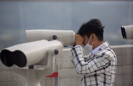 Un hombre surcoreano mira a través de sus binoculares hacia el lado norcoreano de Gaepung-gun.