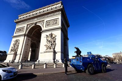 Gendarmes franceses instalan descienden de un vehículo armado VBRG estacionado junto al Arco del Triunfo en París.