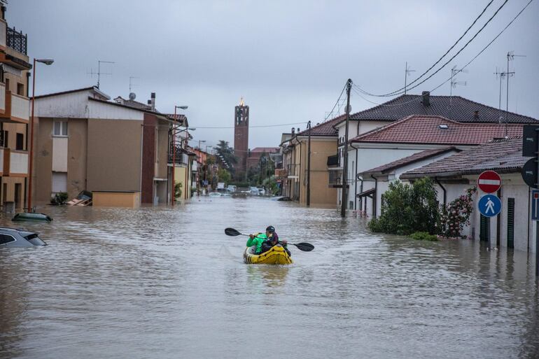 Cesena (Italia), 17/05/2023.- Un ciudadano con un kayak navega entre las casas inundadas para llevar a tierra a algunas personas atrapadas en sus casas en Cesena. Una nueva ola de lluvias torrenciales está azotando Italia, especialmente la región nororiental de Emilia-Romaña y otras partes de la costa del Adriático. EFE/MAX CAVALLARI
