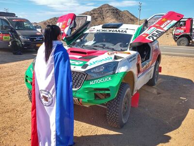 La piloto Andrea Lafarja, con la bandera paraguaya, aguardando el comienzo del Rally Dakar 2022.