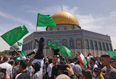 Palestinos ondean banderas dentro del complejo de la mezquita de Al-Aqsa, en Jerusalén.