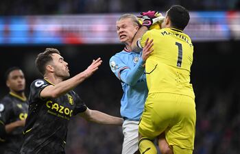 Duro choque entre el argentino Emiliano Martínez, arquero del Aston Villa, y el noruego Erling Haaland, delantero del Manchester City, durante el partido de ayer.