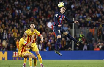 BARCELONA, 10/04/2023.- El mediocampista del FC Barcelona Gavi (d) despeja de cabeza durante el partido de fútbol de la jornada 28 de LaLiga que FC Barcelona y Girona FC juegan este lunes en el Camp Nou. EFE/ Toni Albir