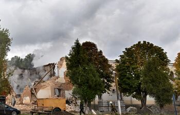 Bomberos voluntarios intentan sofocar el fuego dejado por un dron iraní sobre un complejo en Ucrania. (AFP)